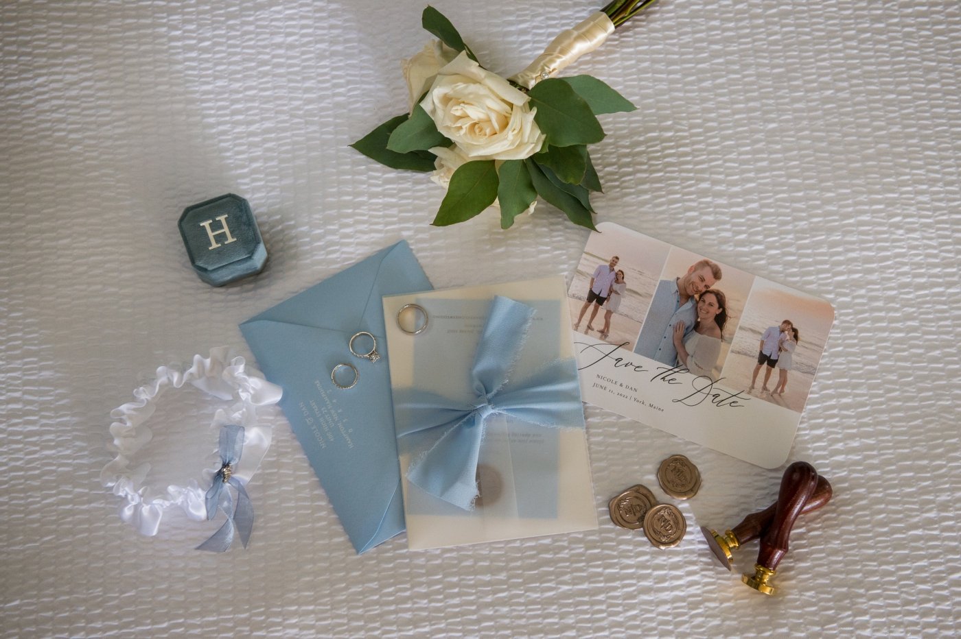 flatlay of blue and wedding wedding stationery and accessories