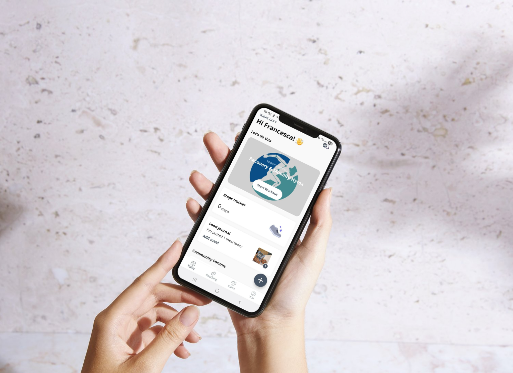 Hand holding a phone using the Everfit fitness app