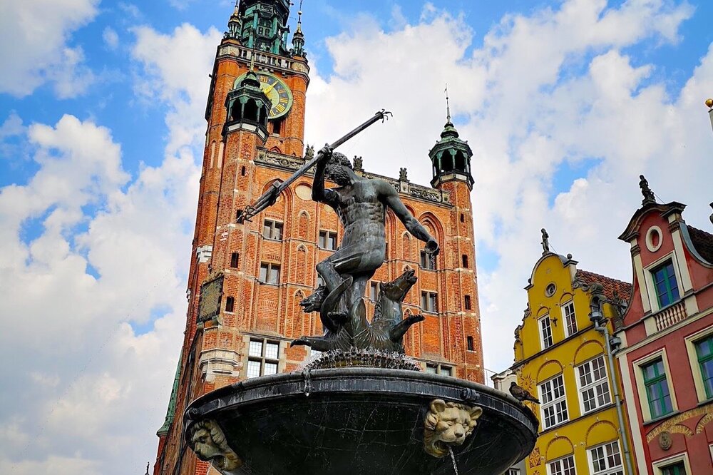 Iconic fountain of Neptune with Gdansk’s town hall towering behind it