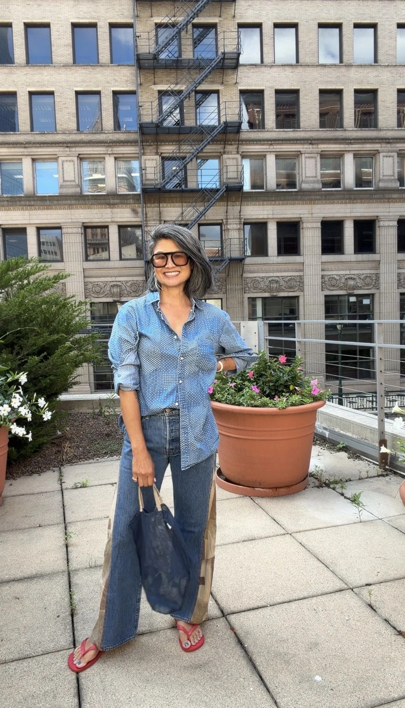 Woman wearing a mix-and-match summer outfit with patterned denim and statement pieces