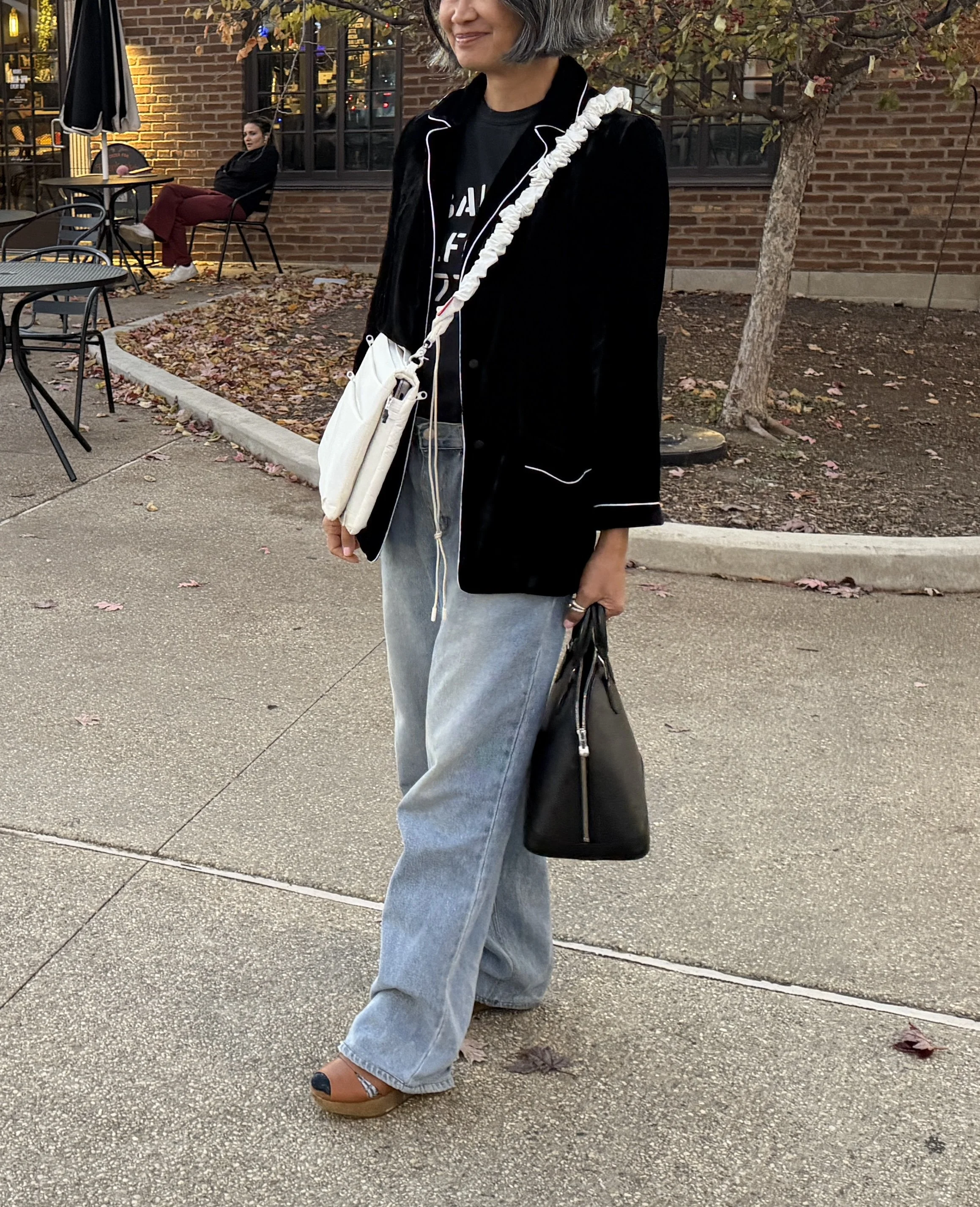 Outfit detail showing dual bag styling — functional laptop bag paired with a structured designer handbag