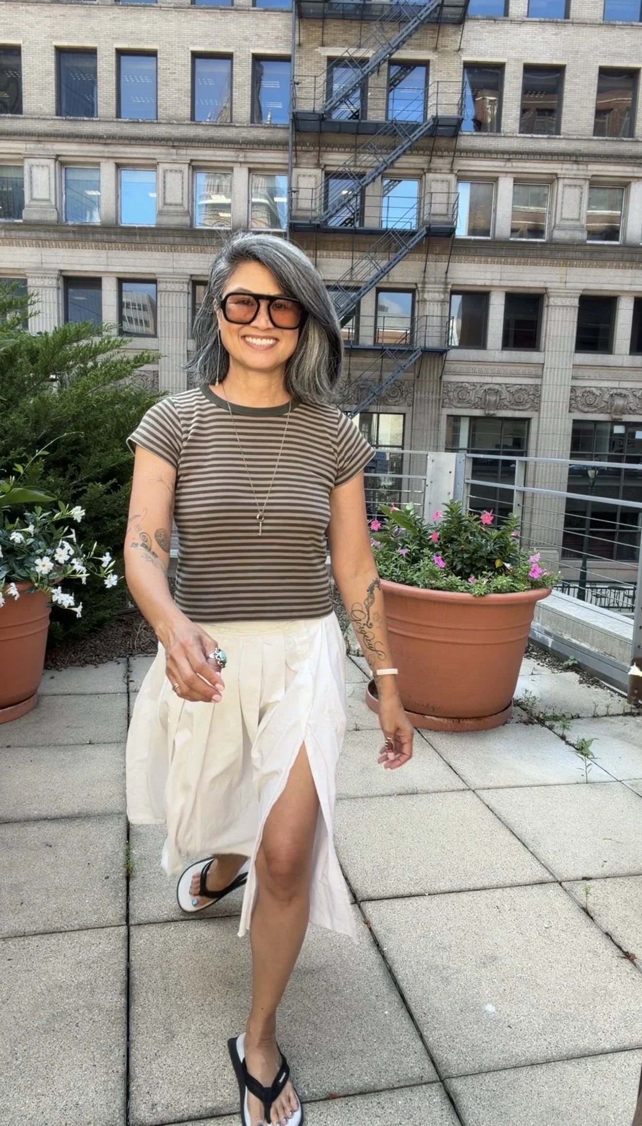 Stylish summer travel outfit for women over 50 featuring layered patterns and contrasting textures