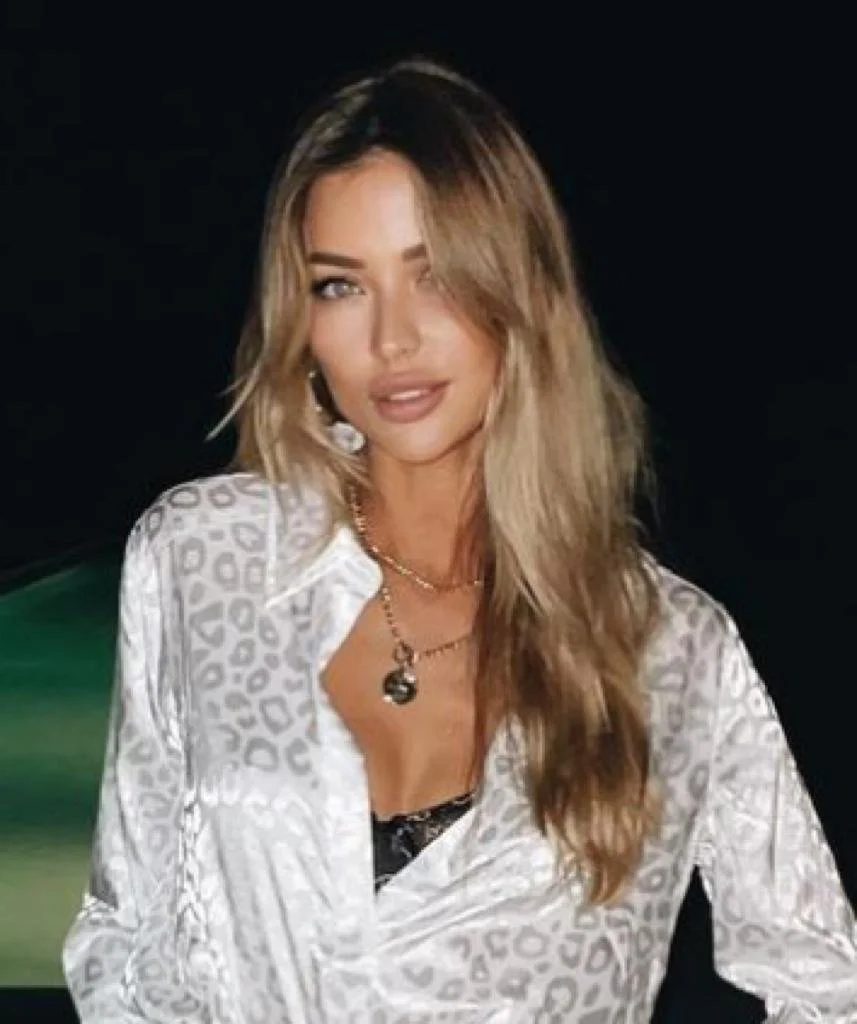 A woman posing in a white shirt