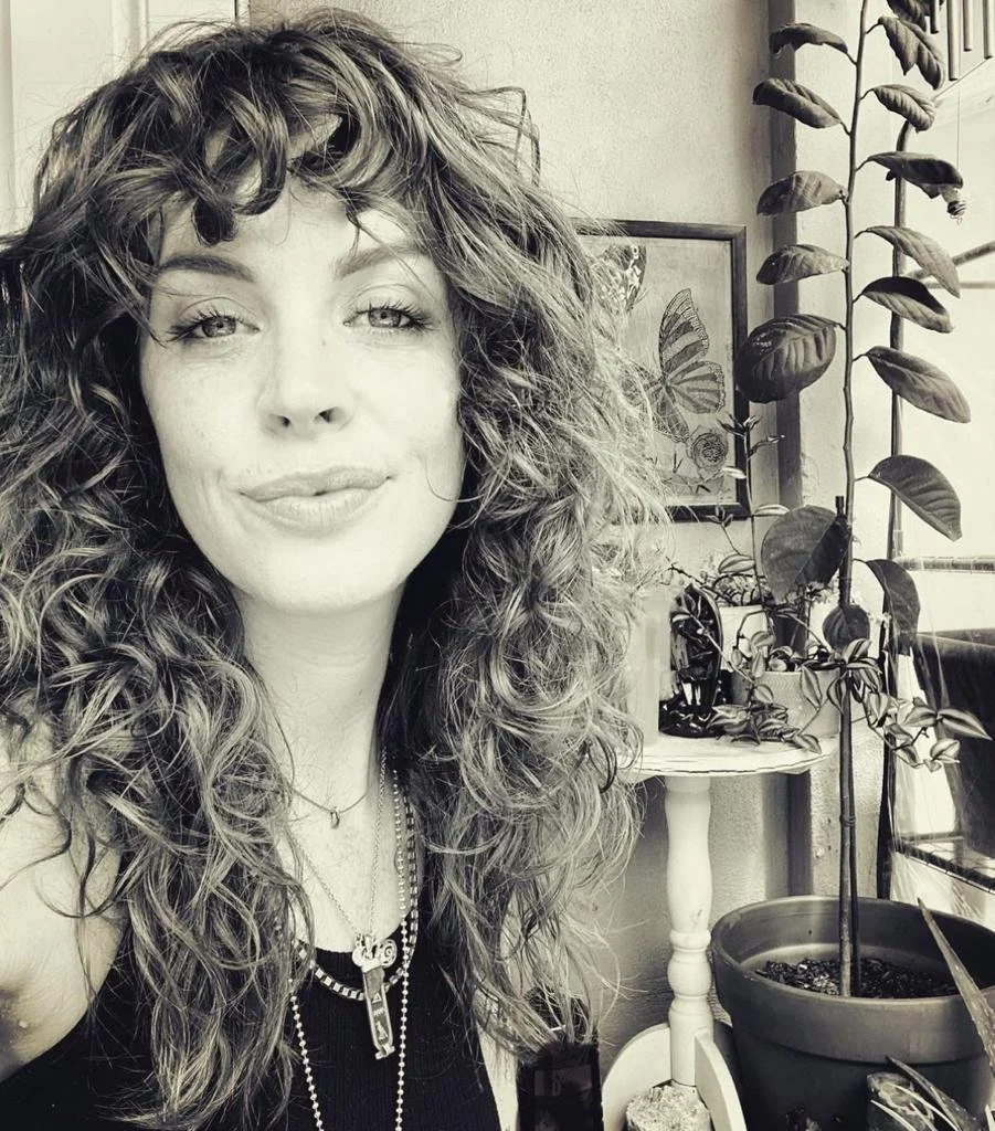 A woman with curly hair smiling