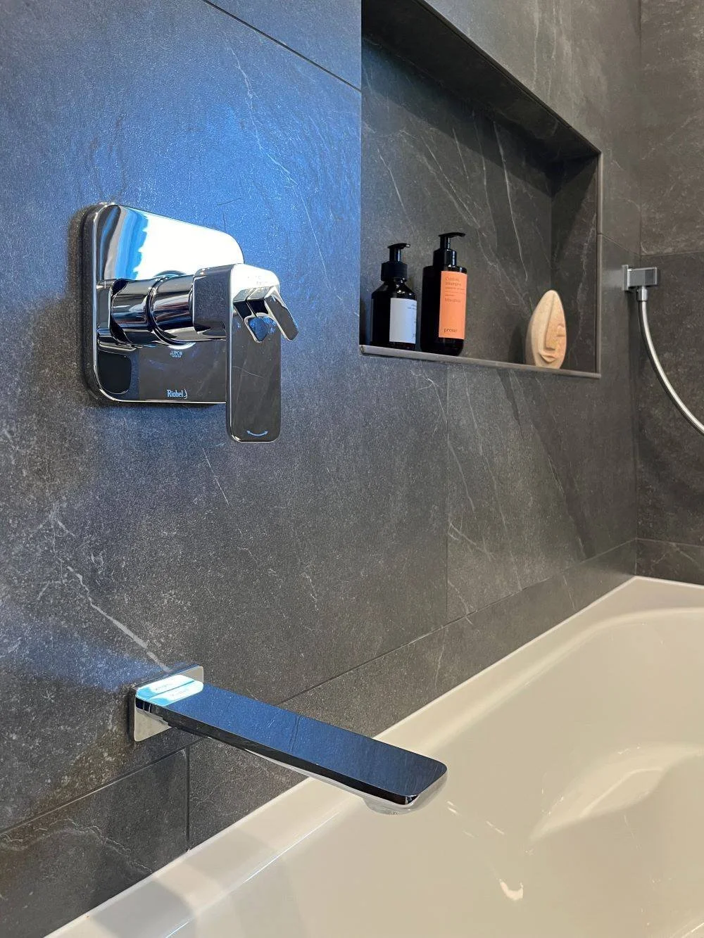 Chrome plumbing fixtures on slate coloured tiles