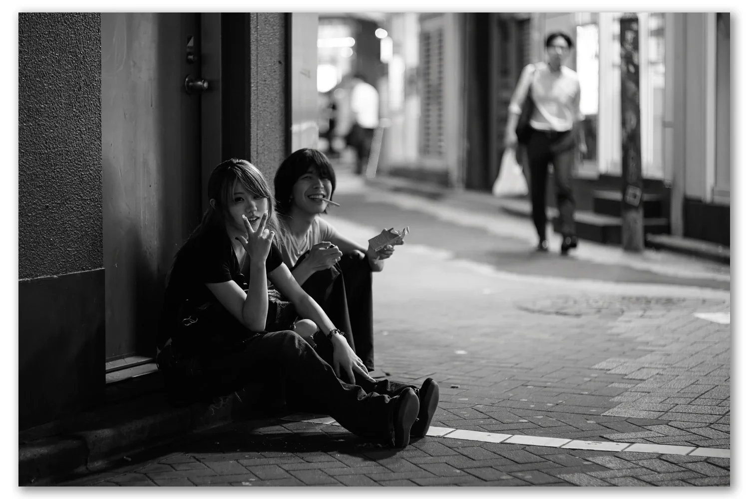 A young couple in the back streets of Shibuya having a cigarette