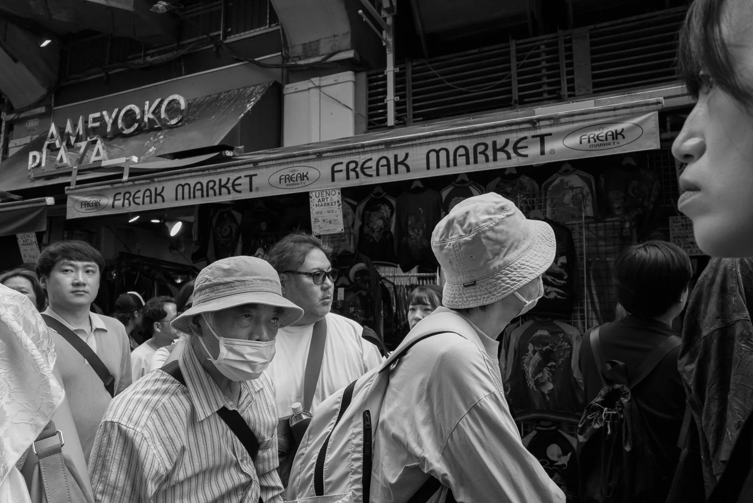 Shoppers in bucket hats crowd beneath the Ameyoko Plaza and Freak Market signs, Ueno