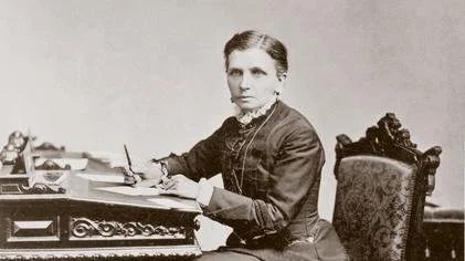 A young Emmeline B. Well writing at a desk