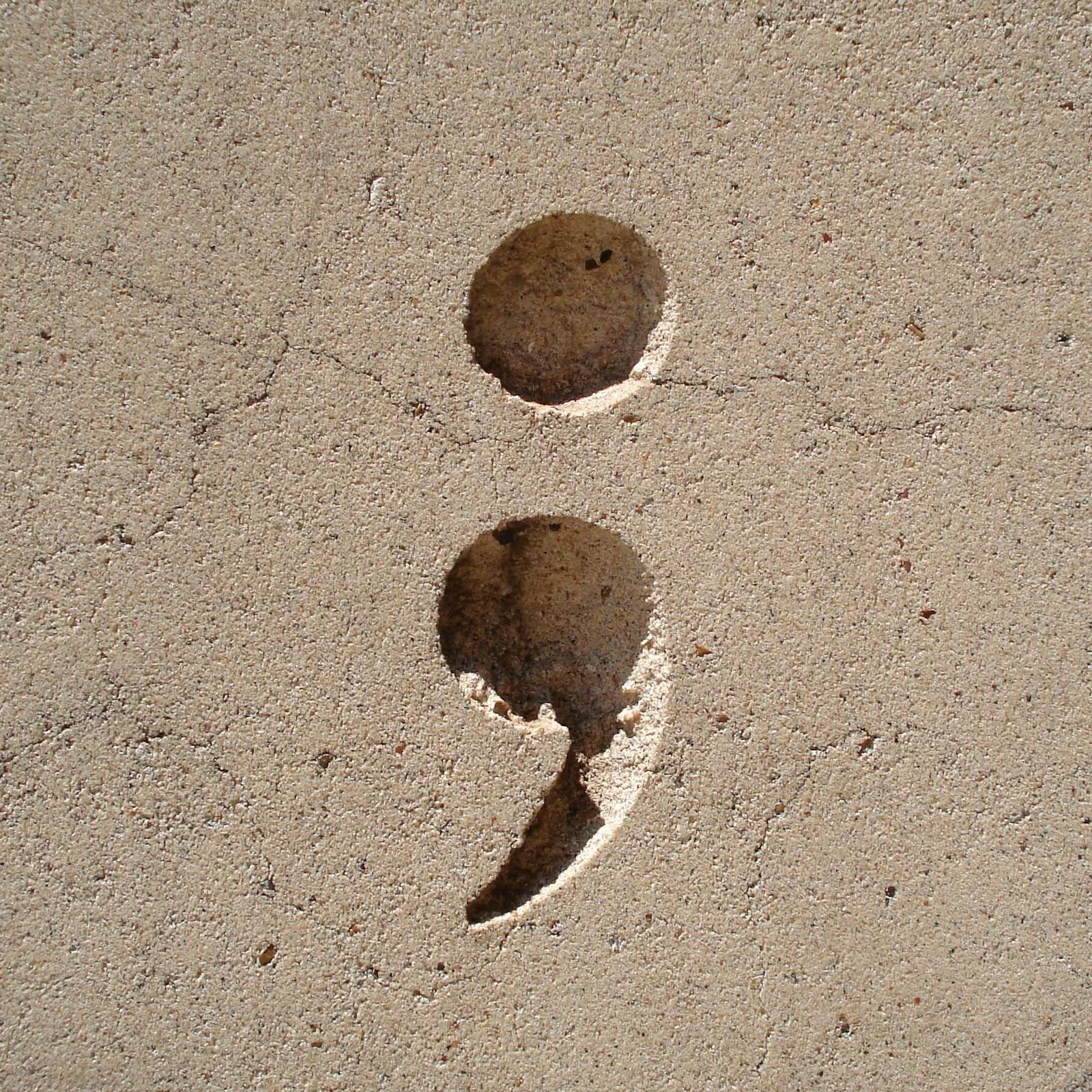 A semicolon carved in stone.