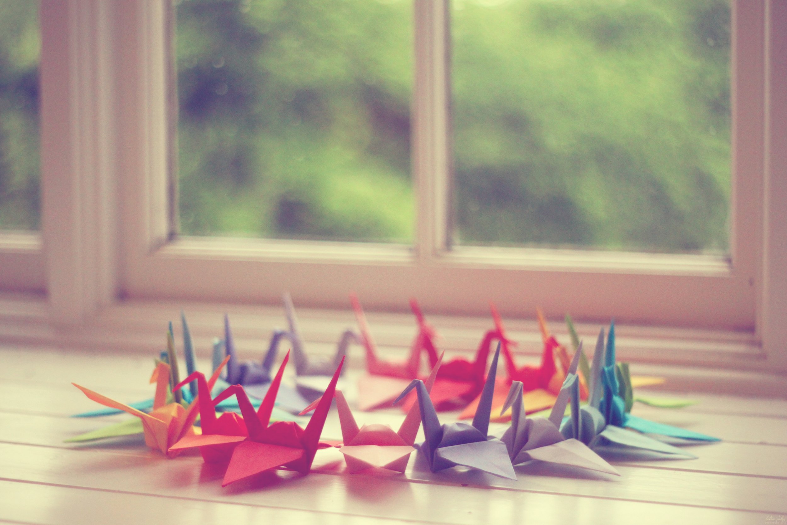 A circle of colourful origami swans made of paper.