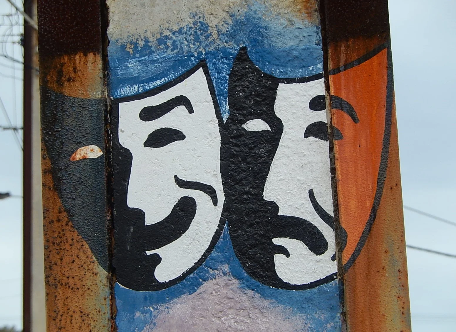 The faces of comedy and tragedy, which make up drama, are painted on a pole.