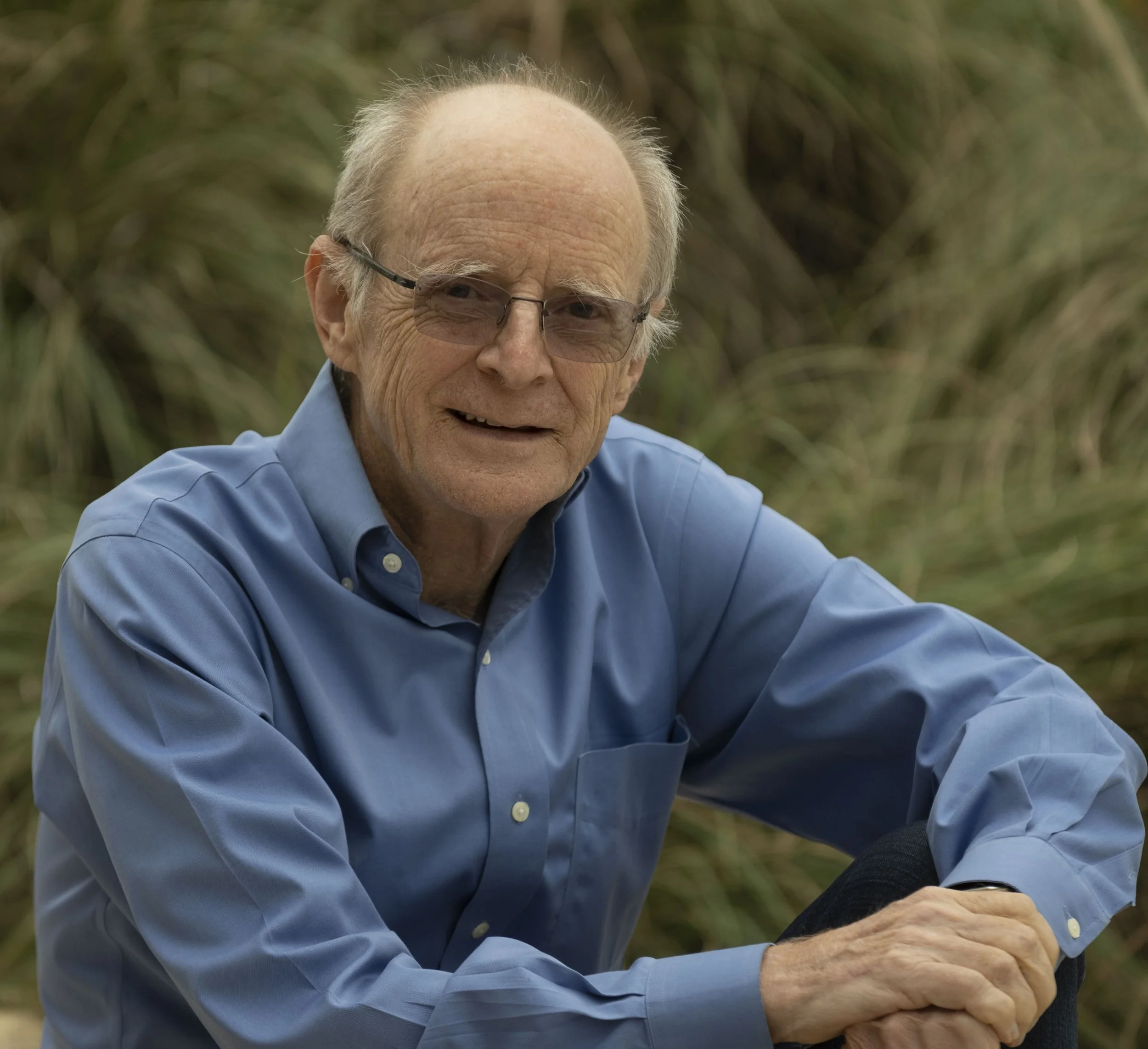 Psychology professor James Pennebaker. He is smiling at the camera and wearing a cornflower blue button-up shirt.