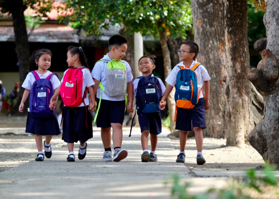 First graders grab hands on their way back to class after receiving their Presidio Education® backpacks with school supplies. Presidio Education®, 2018.