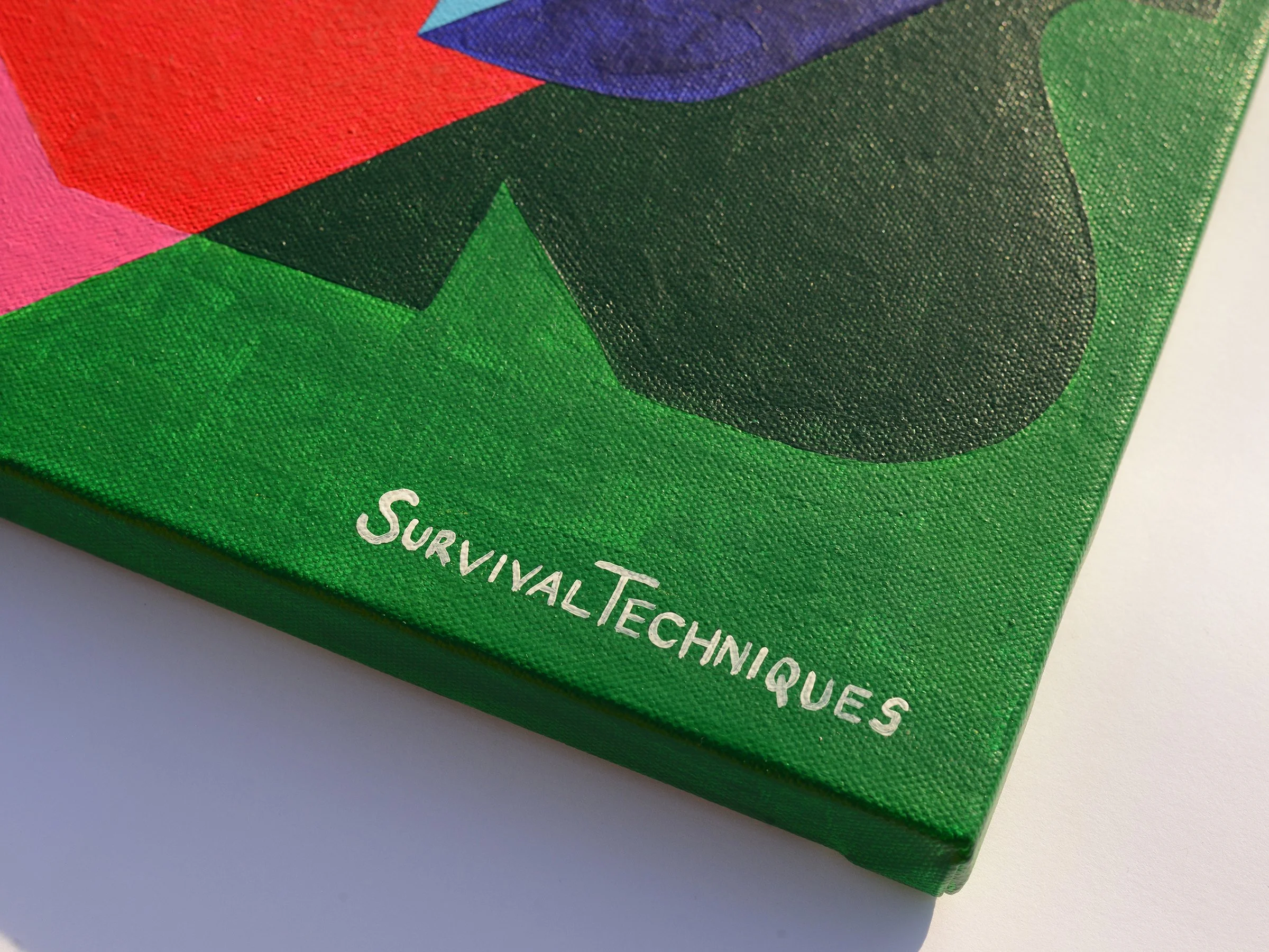 Angled close-up of the canvas corner showing the Survival Techniques signature on a deep green background.