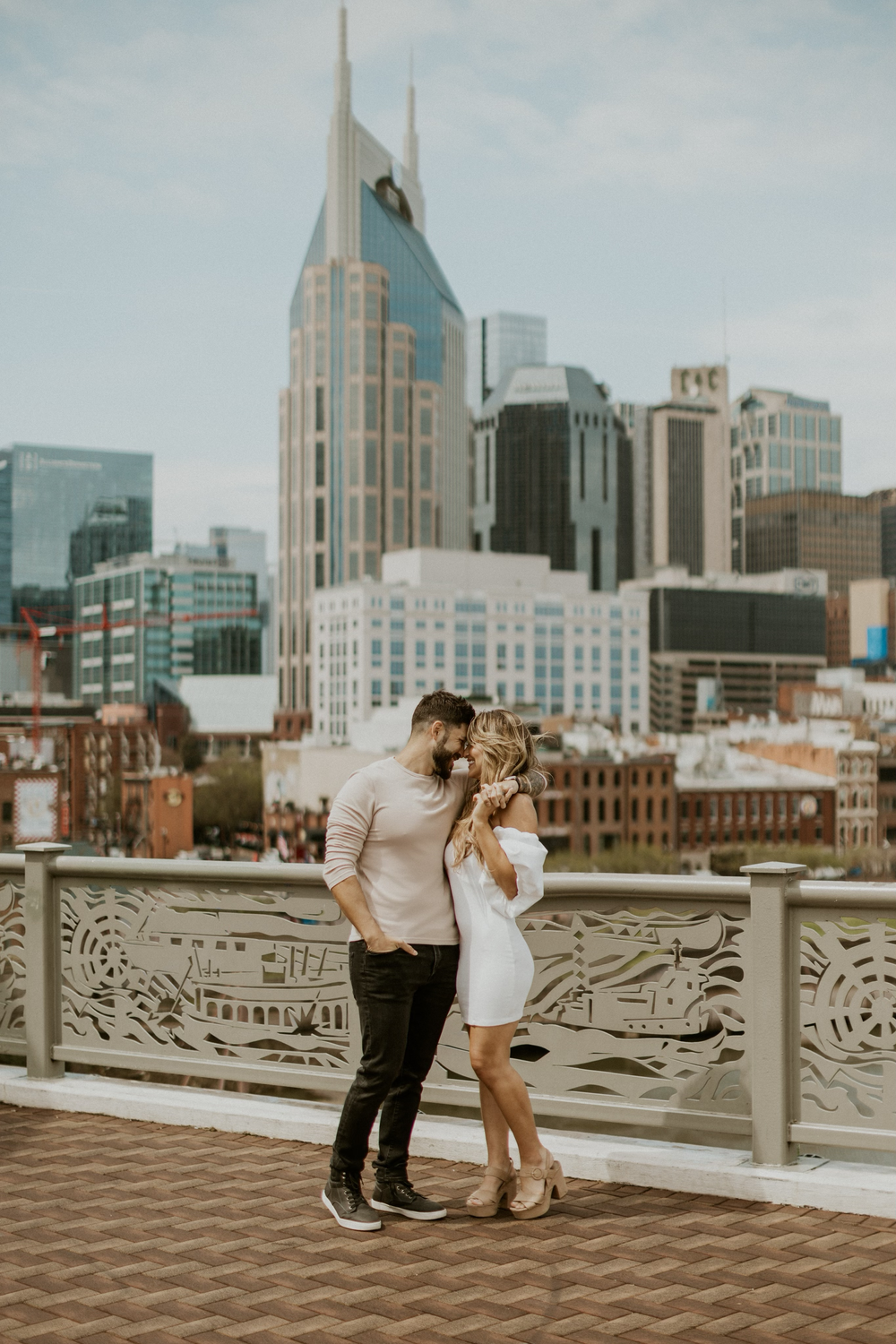 Couple sharing their love with one another on walking bridge.