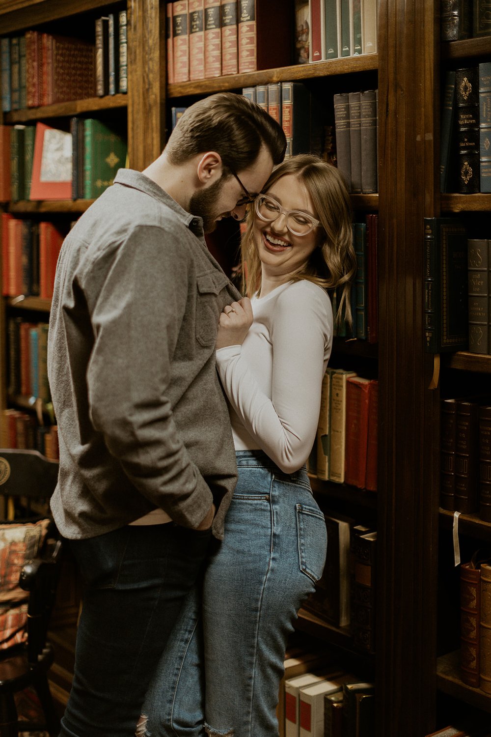 The couple flirt together in the antique book store.