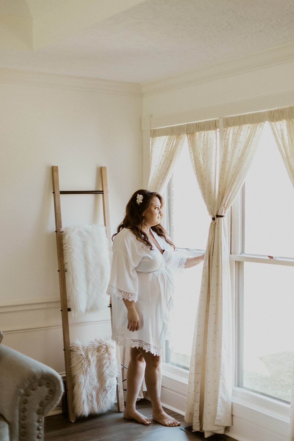 Bride standing at the window admiring her wedding venue
