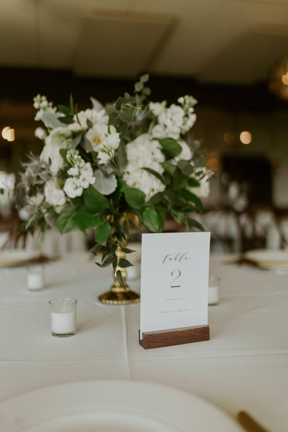 White floral centerpiece with table number for guests.