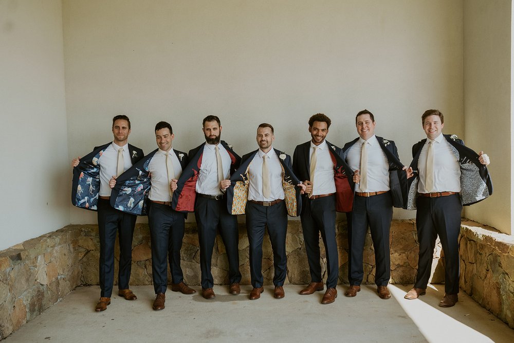 All groomsmen showing off the inside of their jackets.