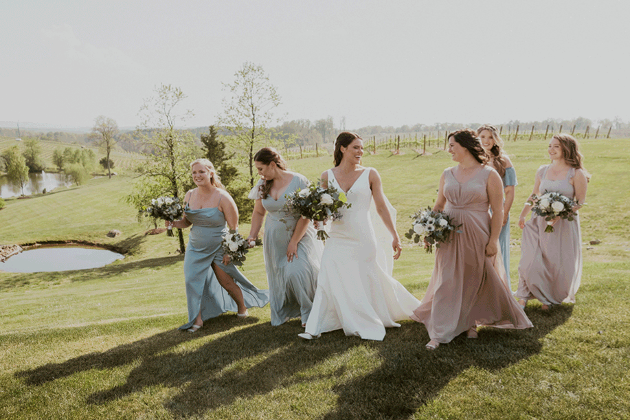 Bride and bridesmaids walk together laughing and enjoying the celebration.