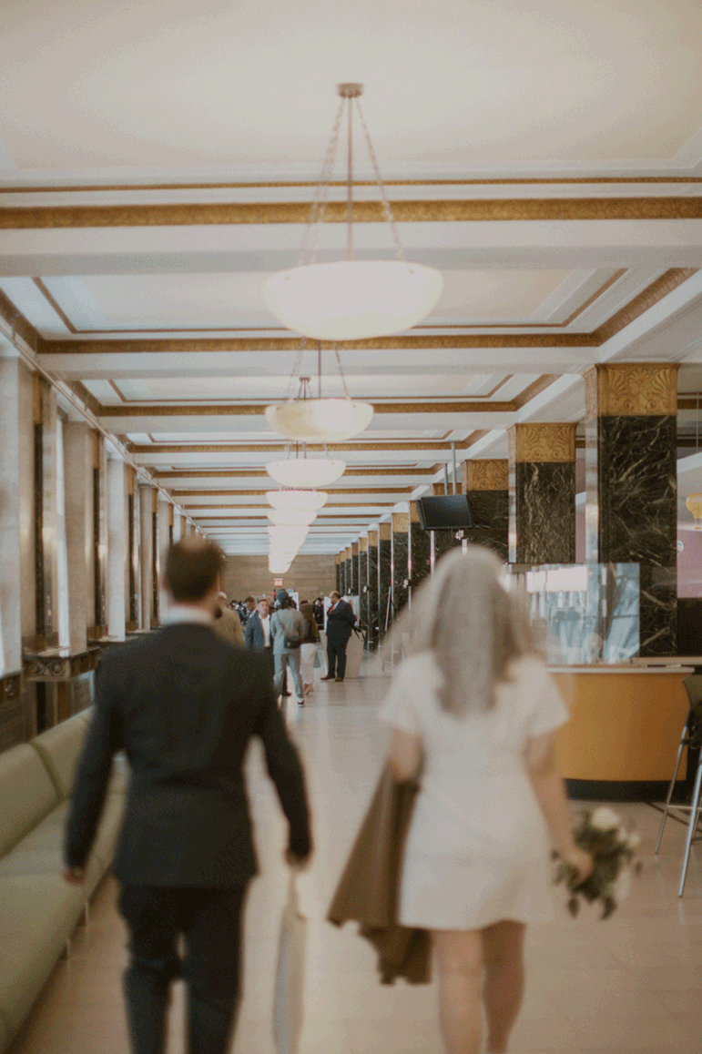 Bride and groom walking the hall of the courthouse to prepare for their elopement ceremony.