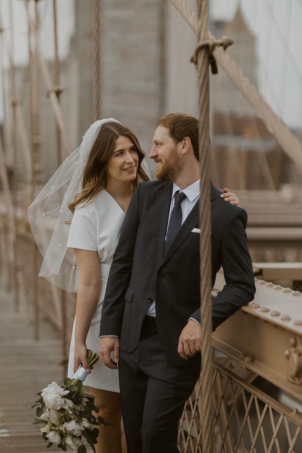 Maren looks at her new husband while relaxing on the Brooklyn Bridge.