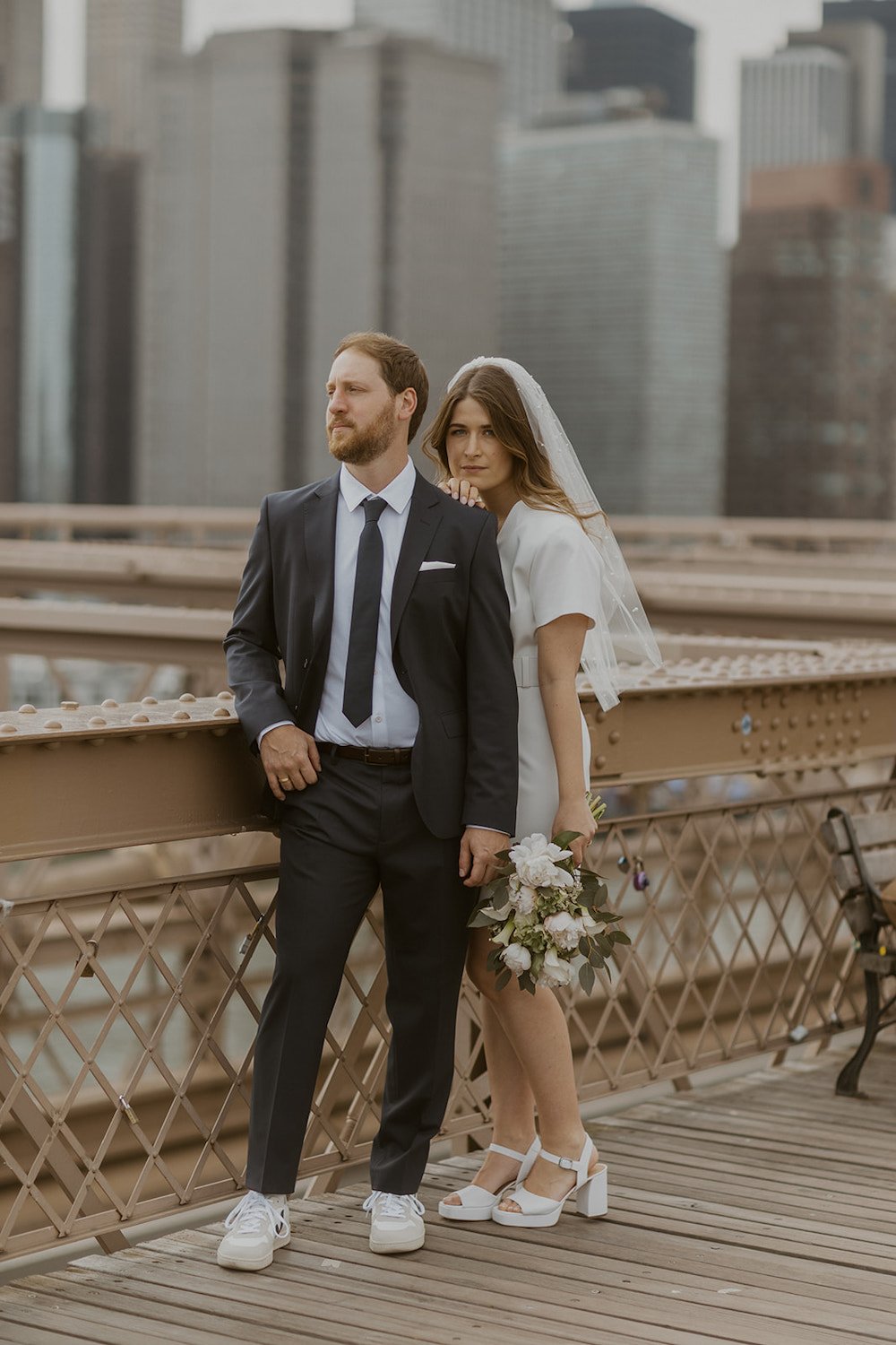 Couple standing together on the Brooklyn Bridge enjoying their view.