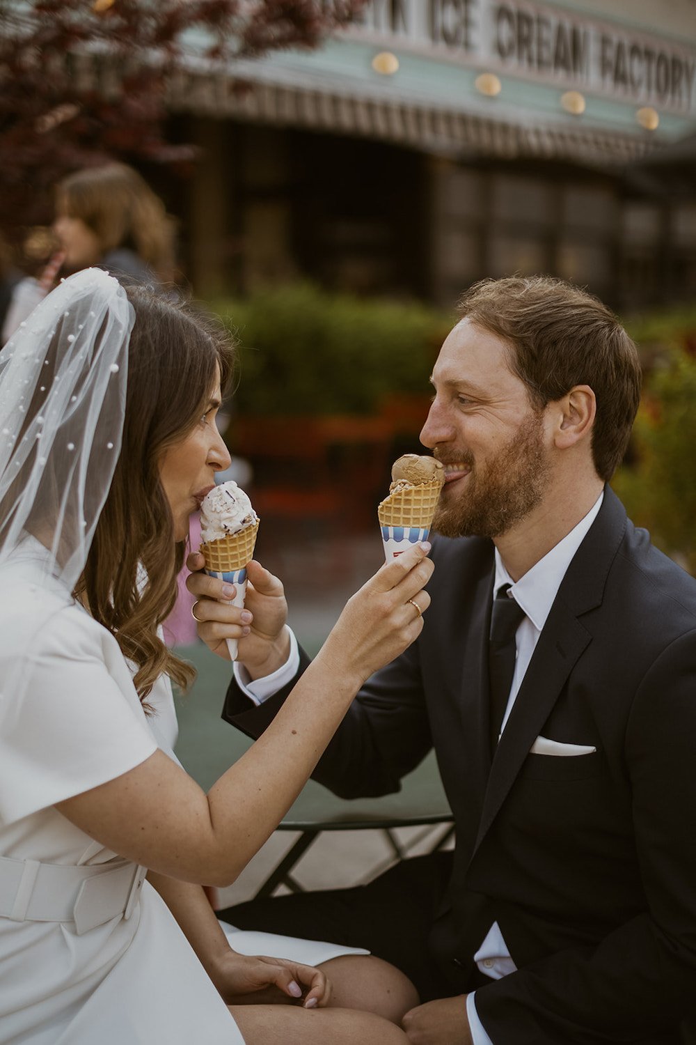 The couple share one anothers ice cream giving each other a little taste. 