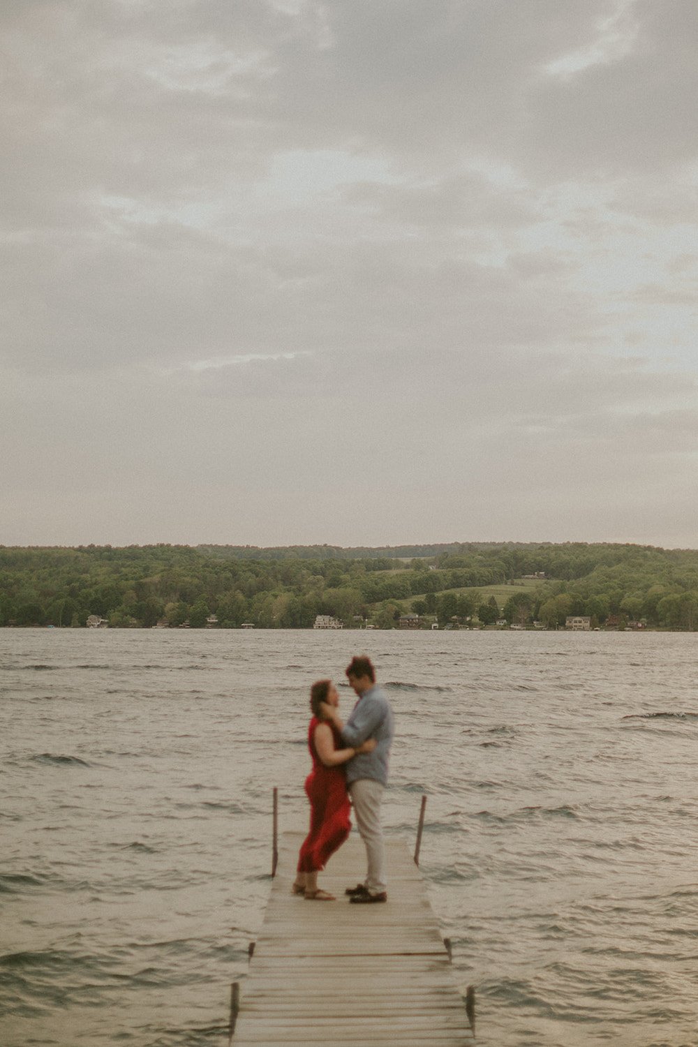 Couple standing on the pier together.