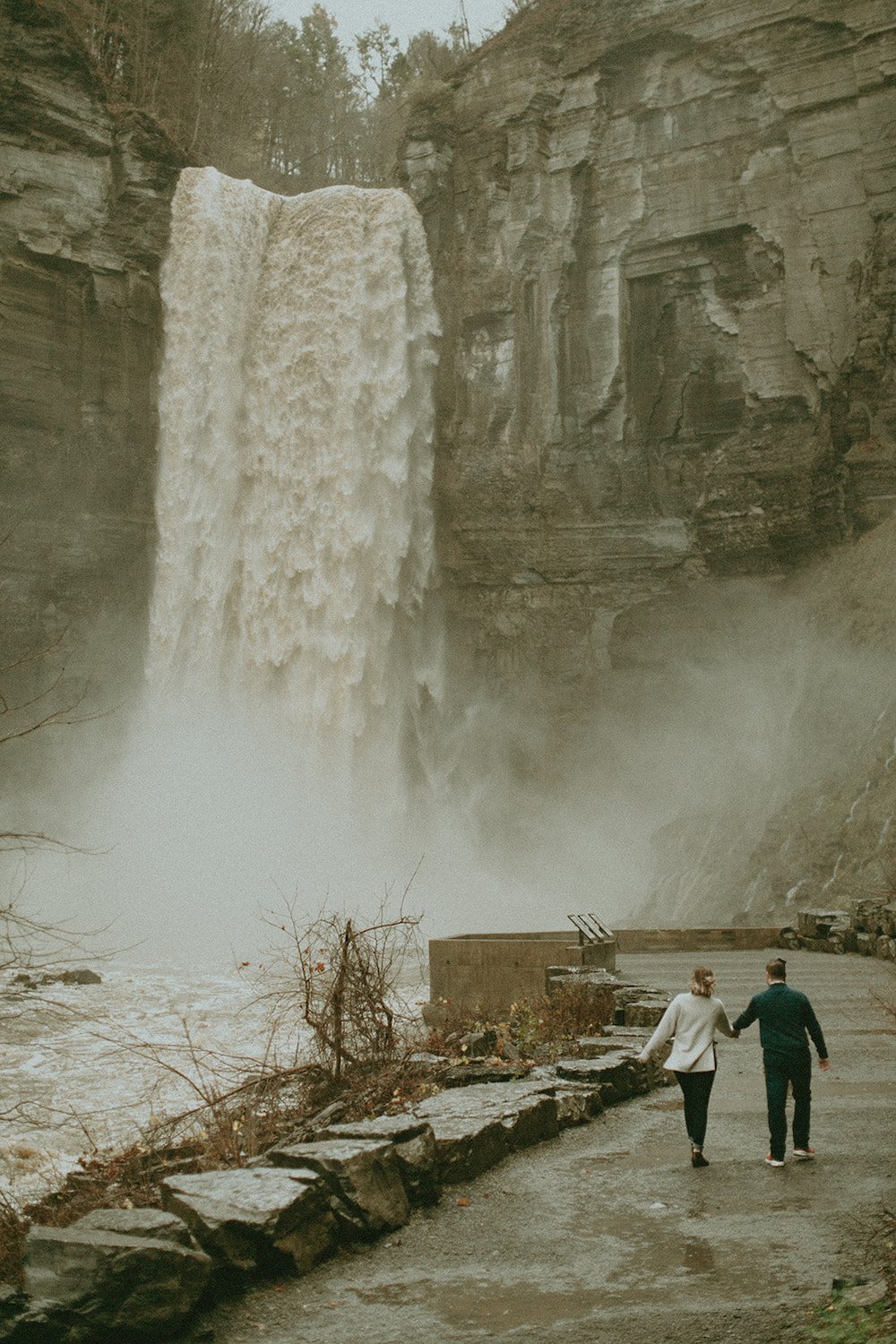 Couple walking along the waterfall over winter.
