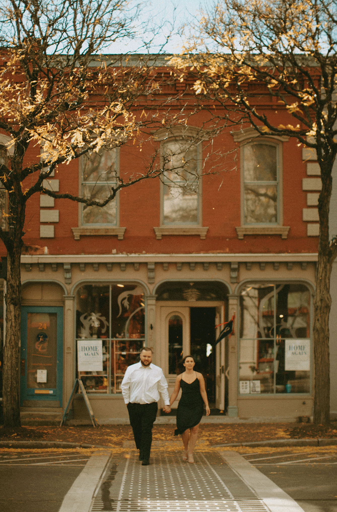 Couple walking across the street together holding hands. 