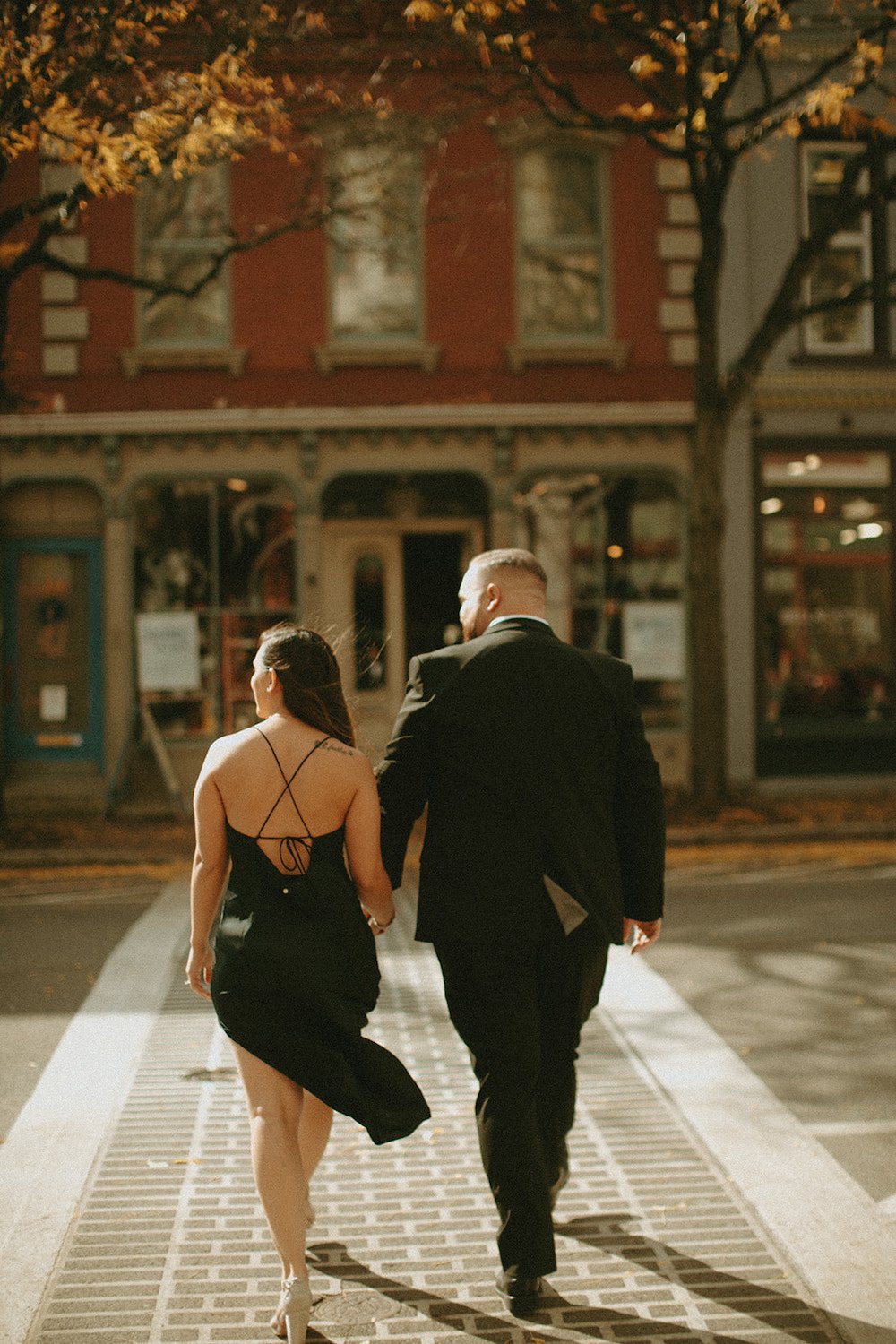 Couple crossing the street while holding hands.