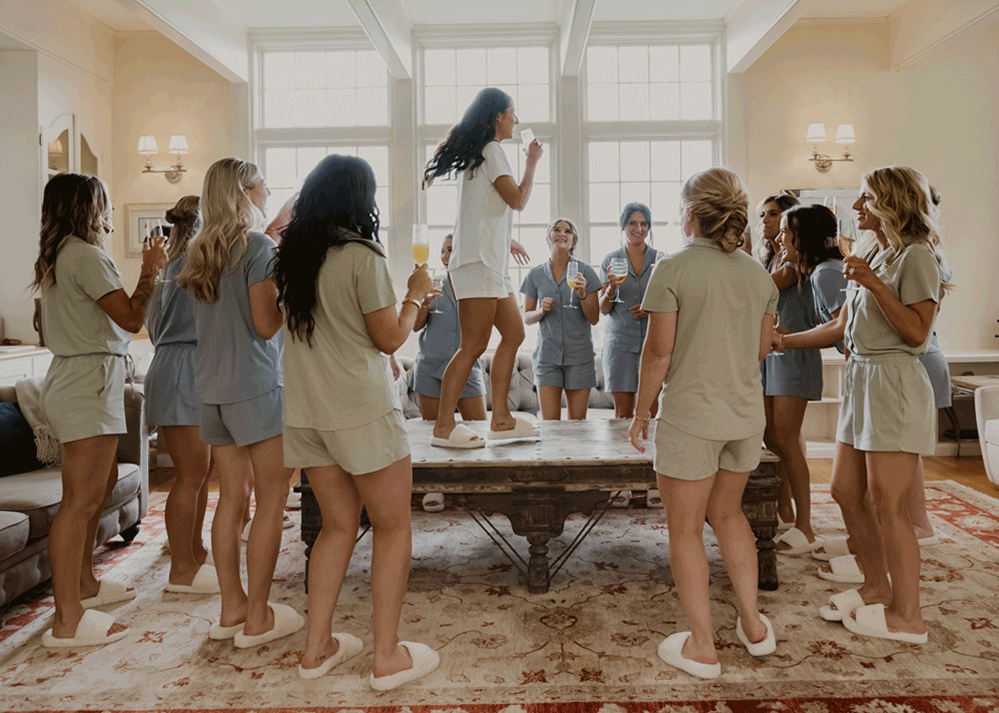 Bride pumps her bridal party up this morning standing on top of the coffee table dancing.