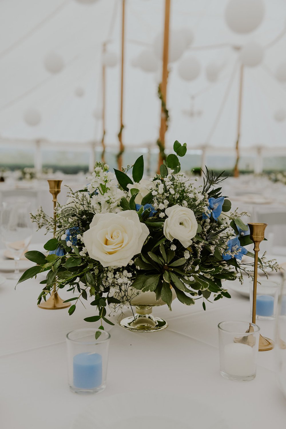 White roses and greenery in vase as the wedding centerpieces. 