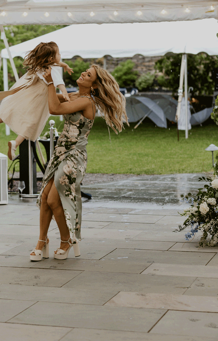 Bridesmaid dances in circles with the flower girl. 
