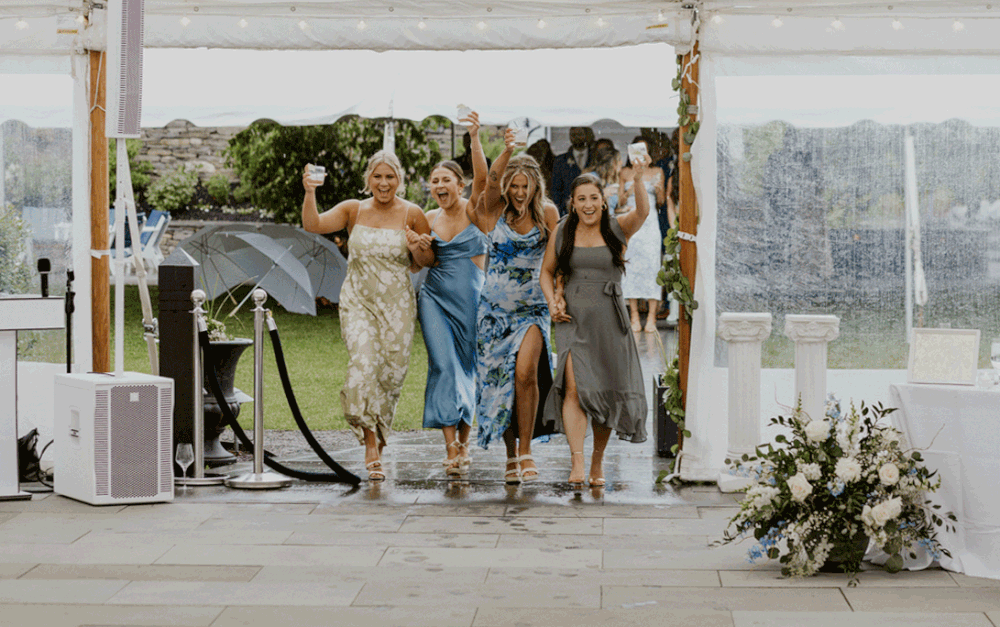 Bridesmaids walk out with cocktails in celebration.