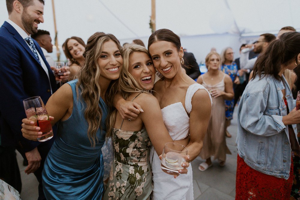 Bride takes photo with two of her bridesmaids.
