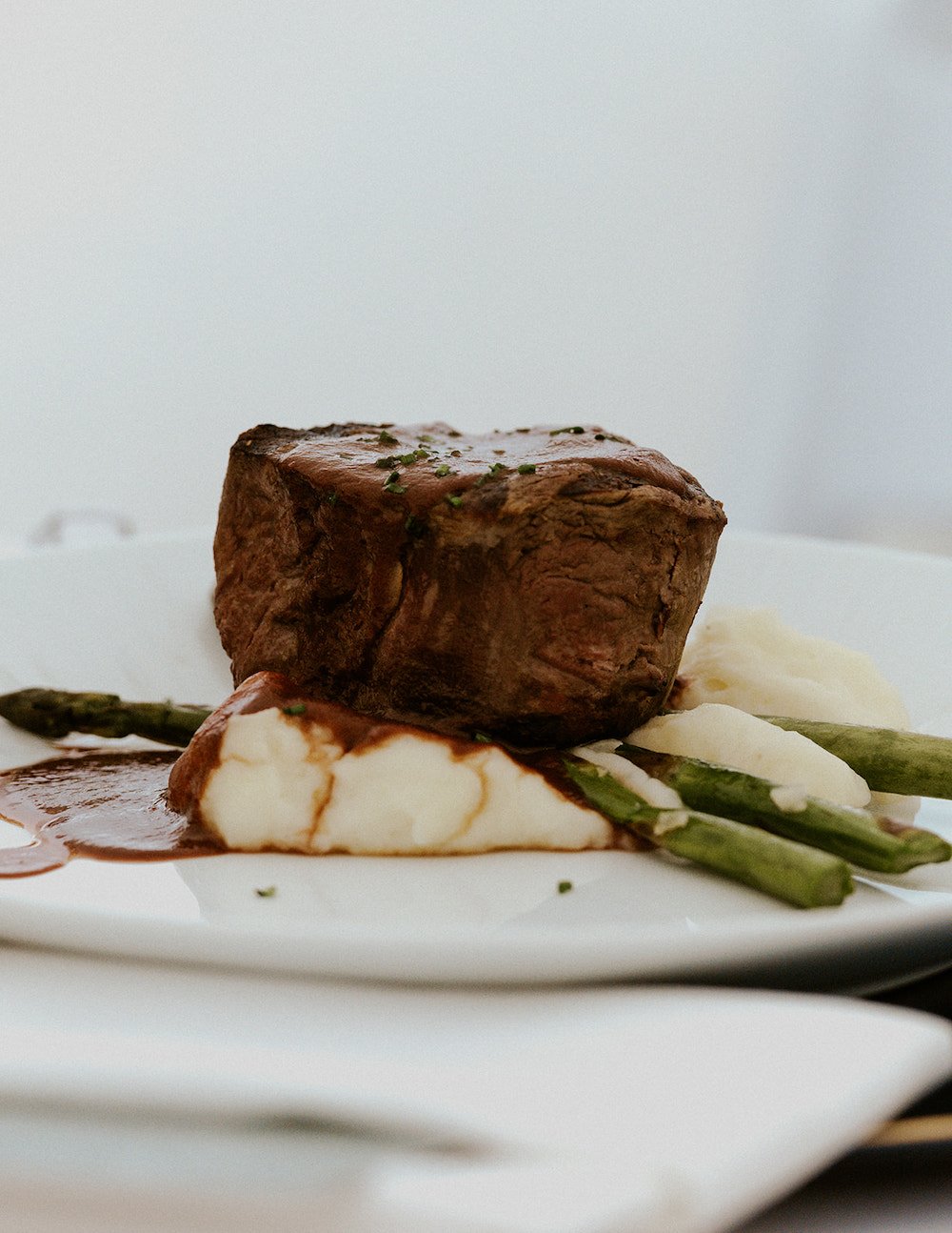 Filet over a mashed potato with asparagus and gravy