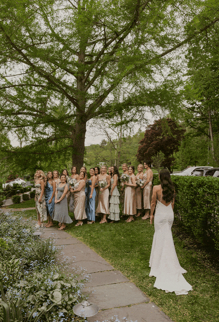 Bride shares a first look with her brides maids to show off her wedding look. 