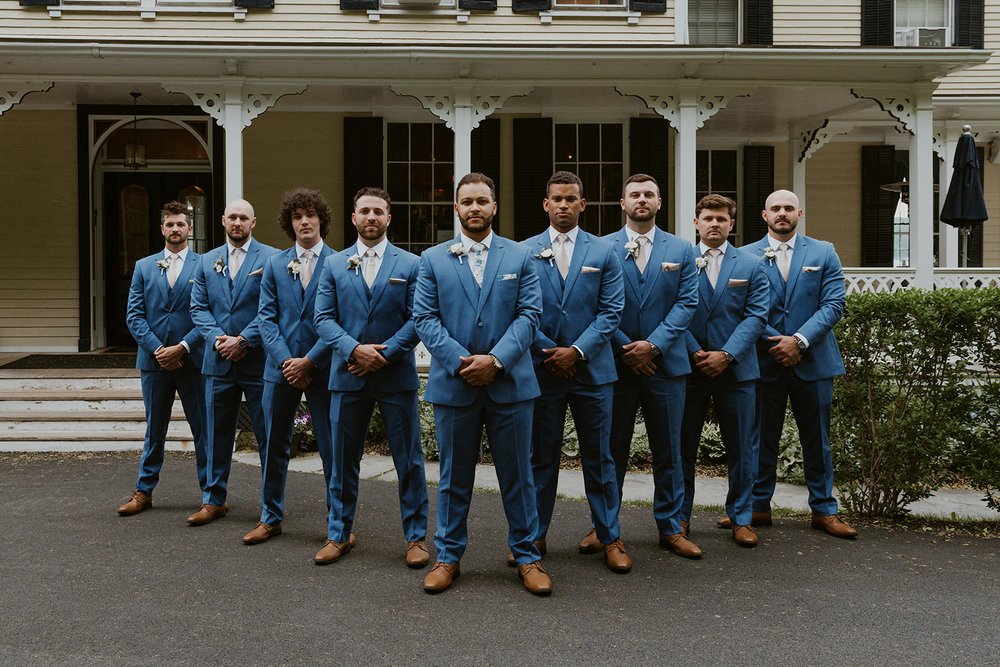 Groomsmen stand infront of the Inn at Taughannock house for a full groomsmen photo.
