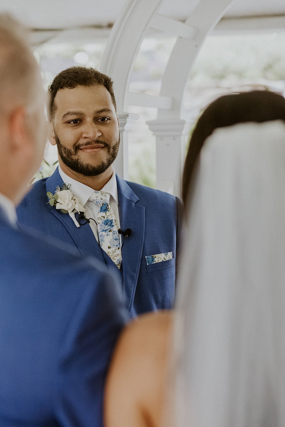 Groom admires his bride while her father gives her away. 