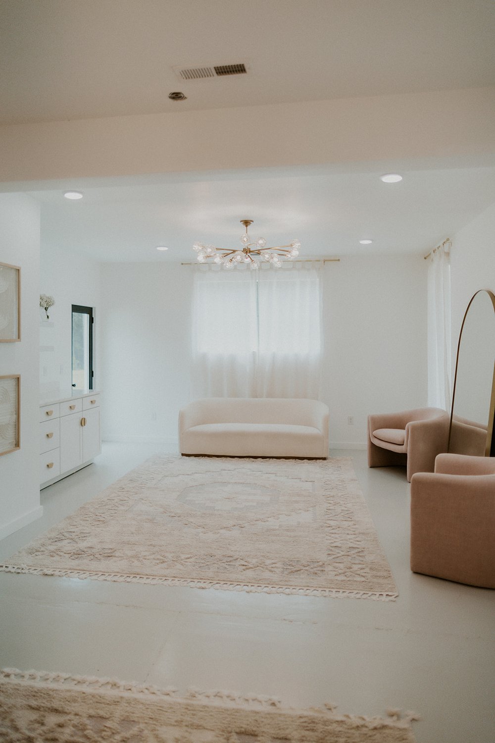 Full view of the bridal sweet with lounge chairs, ivory couch and mirror. 
