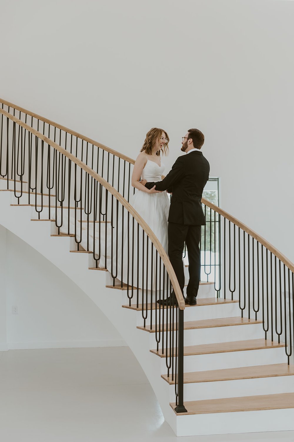 Bride and groom standing on the stairs of the wedding venue enjoying their first look together. 