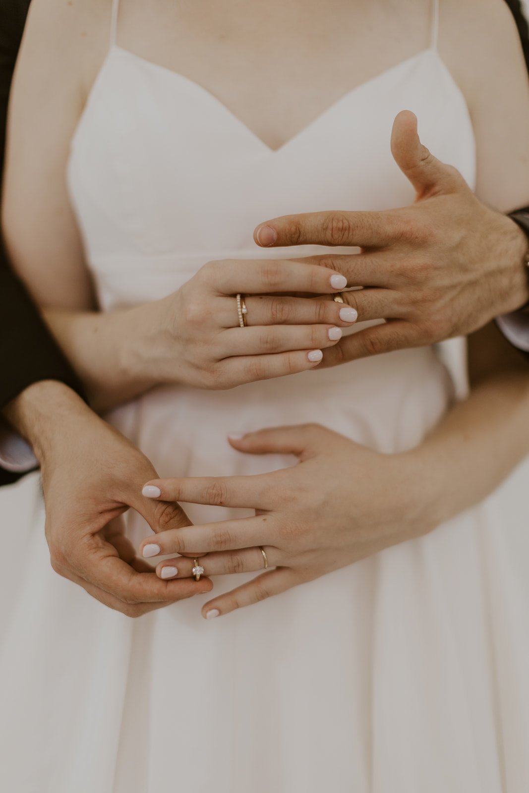 Bride and groom putting each others rings on one another fingers. 