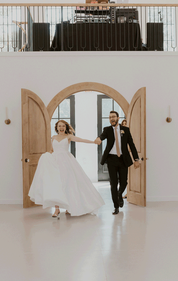 Bride and groom walk out to the reception dance floor after being presented as Mr. &amp; Mrs.