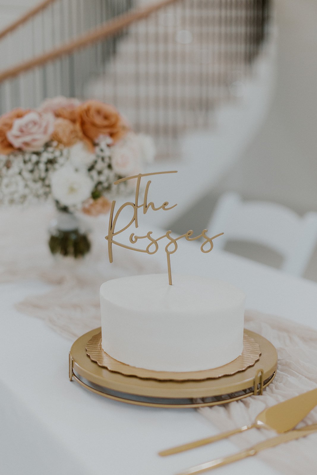 Simple, clean white cake with "The Ross's" cake topper.