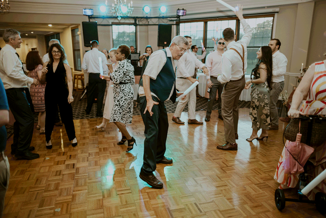 Wedding guest dances from side to side enjoying the beat of the music. 