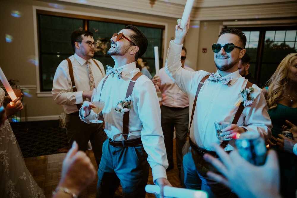 Groomsmen dancing happily with sunglasses on.