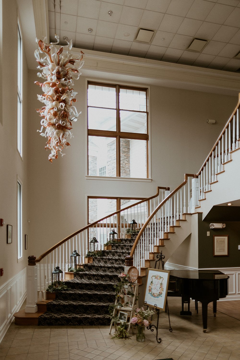 Entry way of the Corning Country club with beautiful glass sculpture hanging from the ceiling and staircase. 