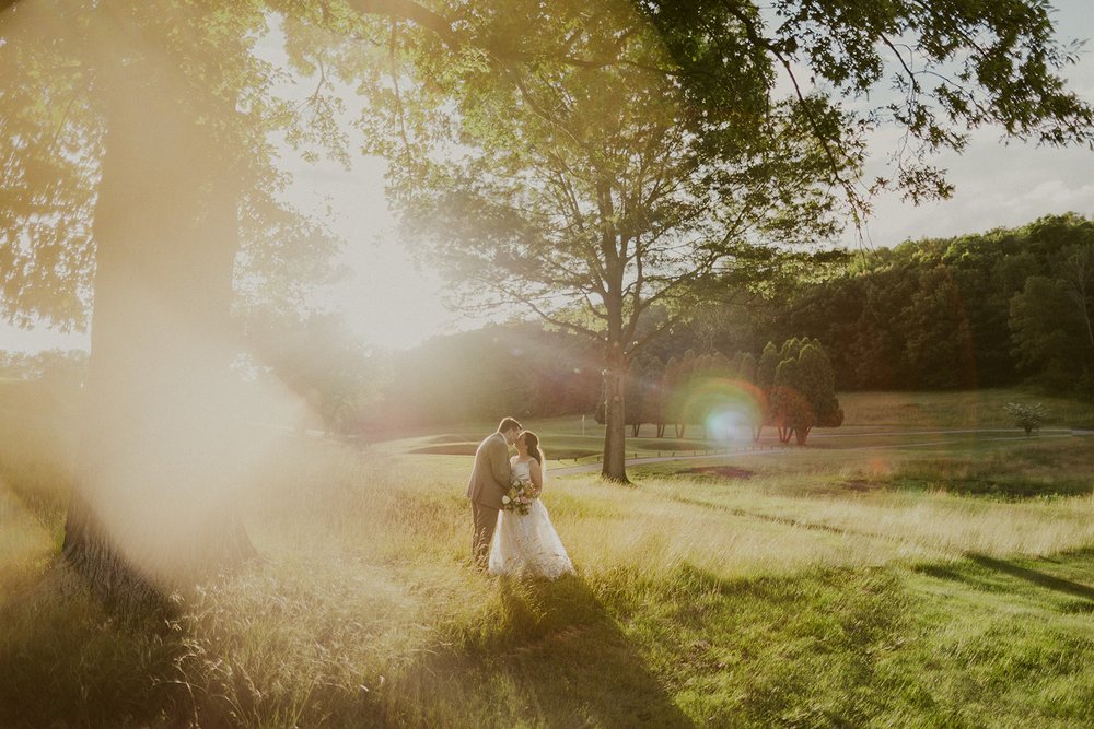 Bride and groom kiss one another during their golden hour photos.